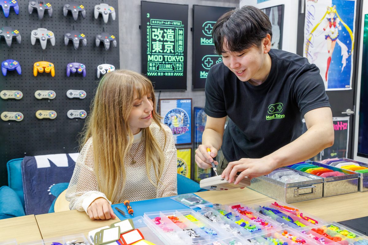A guide helping a smiling participant during the build