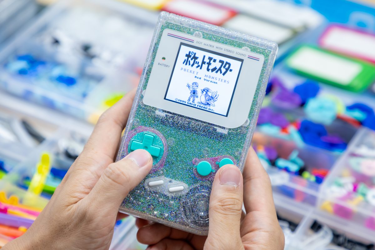 Clear-white Game Boy with its screen lit