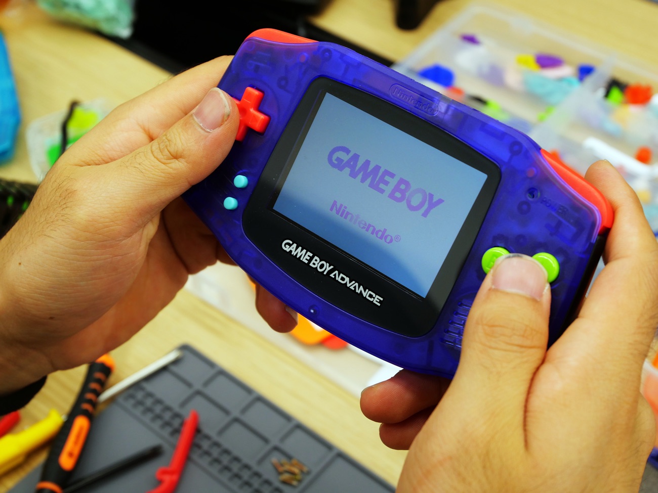 Custom clear-purple Game Boy Advance with red buttons, screen lit