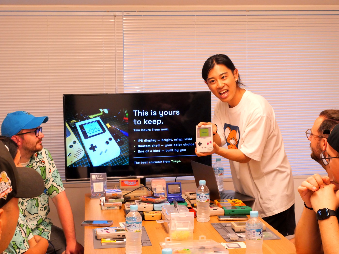 Guide holding up a finished Game Boy in front of the welcome slide
