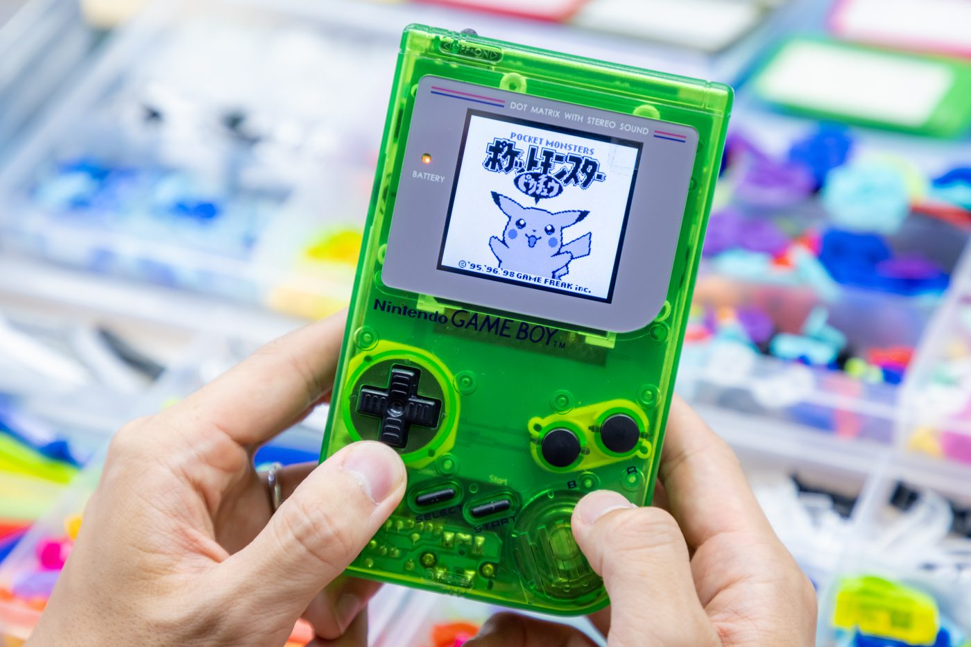 A finished clear-green original Game Boy with its screen lit