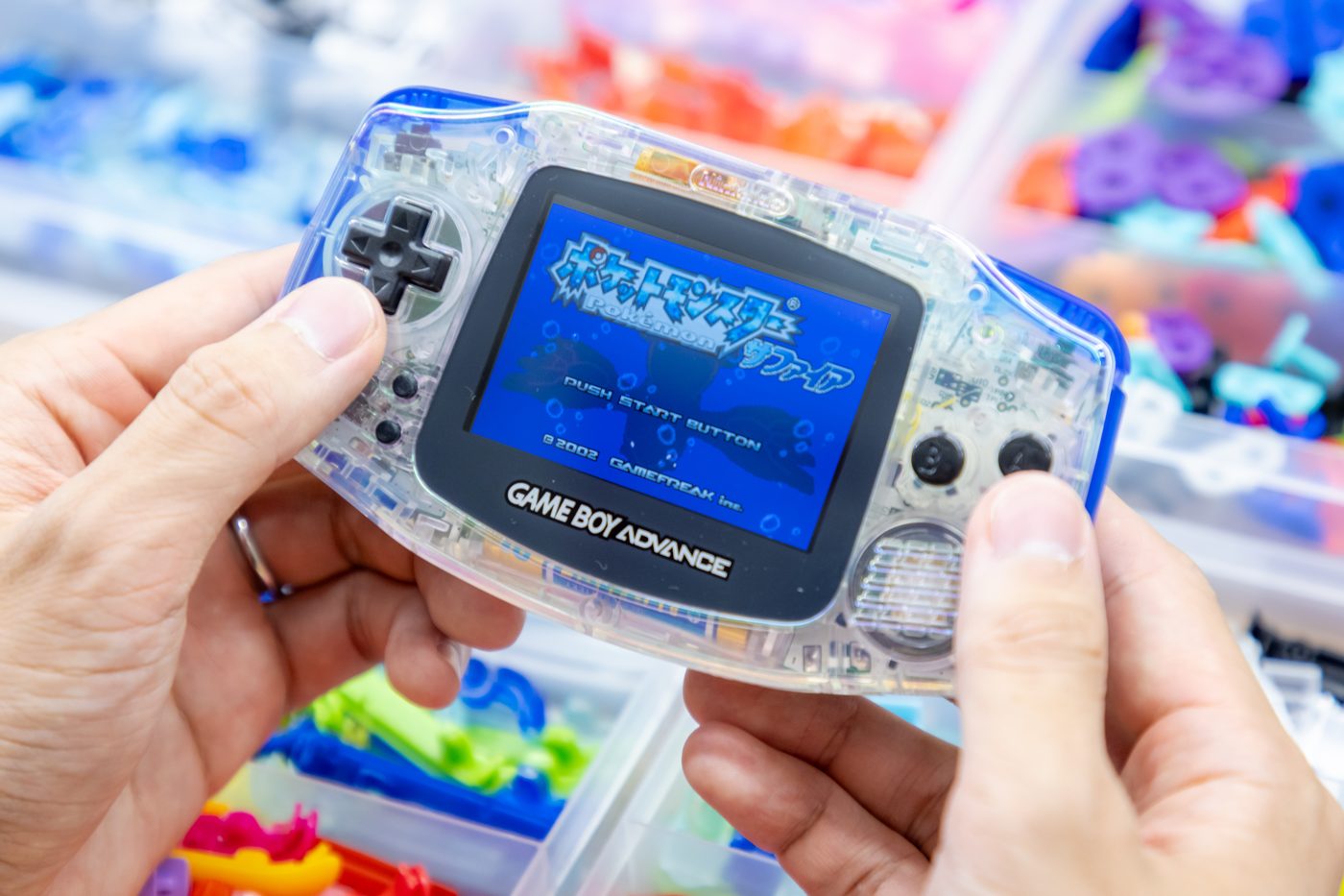 A finished, customized crystal-clear Game Boy Advance with its screen lit