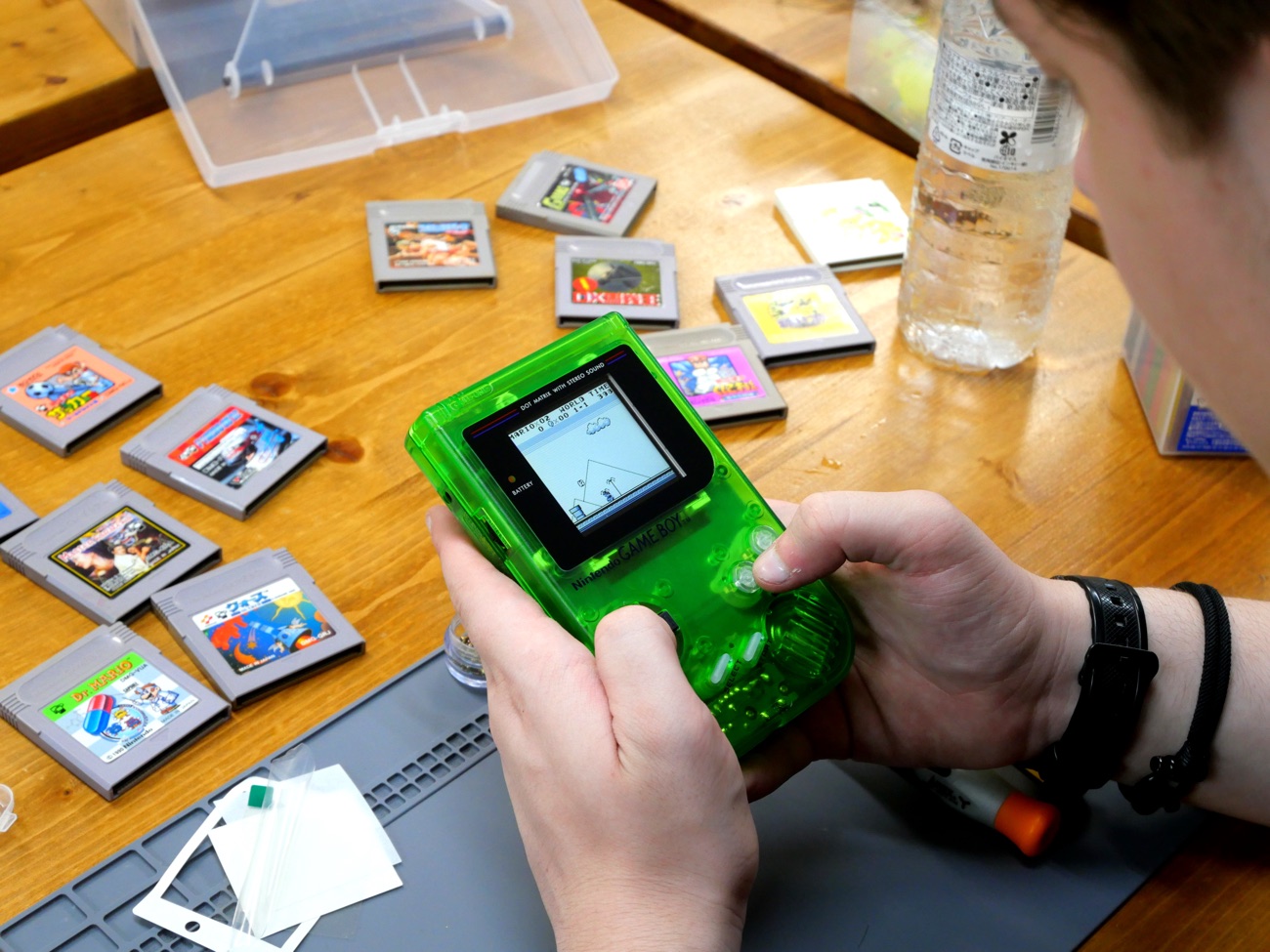 Clear-green Game Boy being played, screen lit