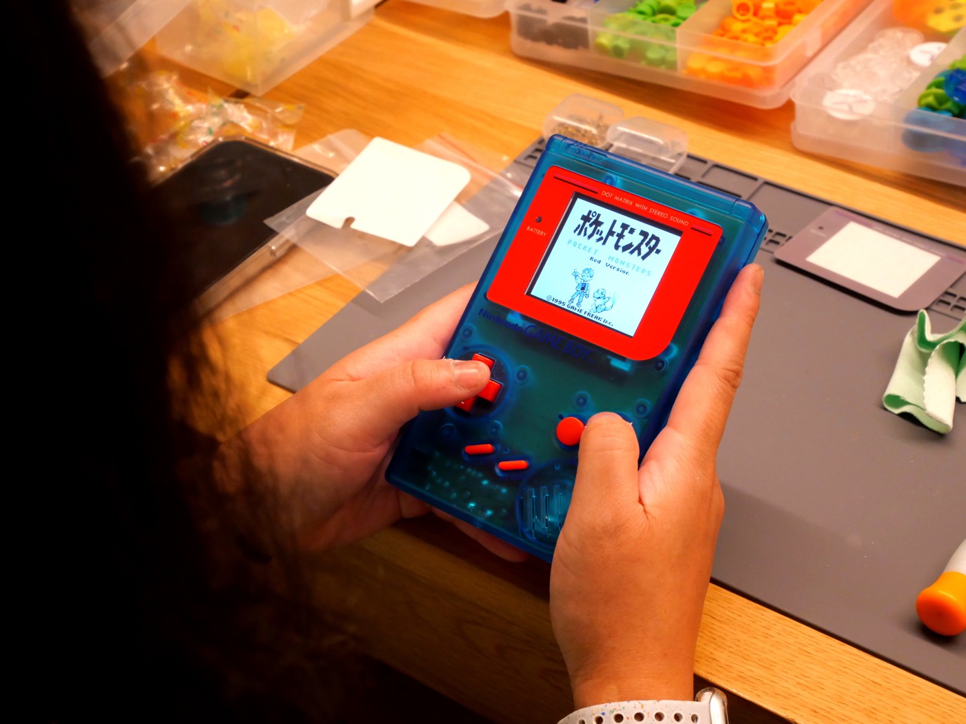 Playing Pokémon on a finished clear-blue Game Boy