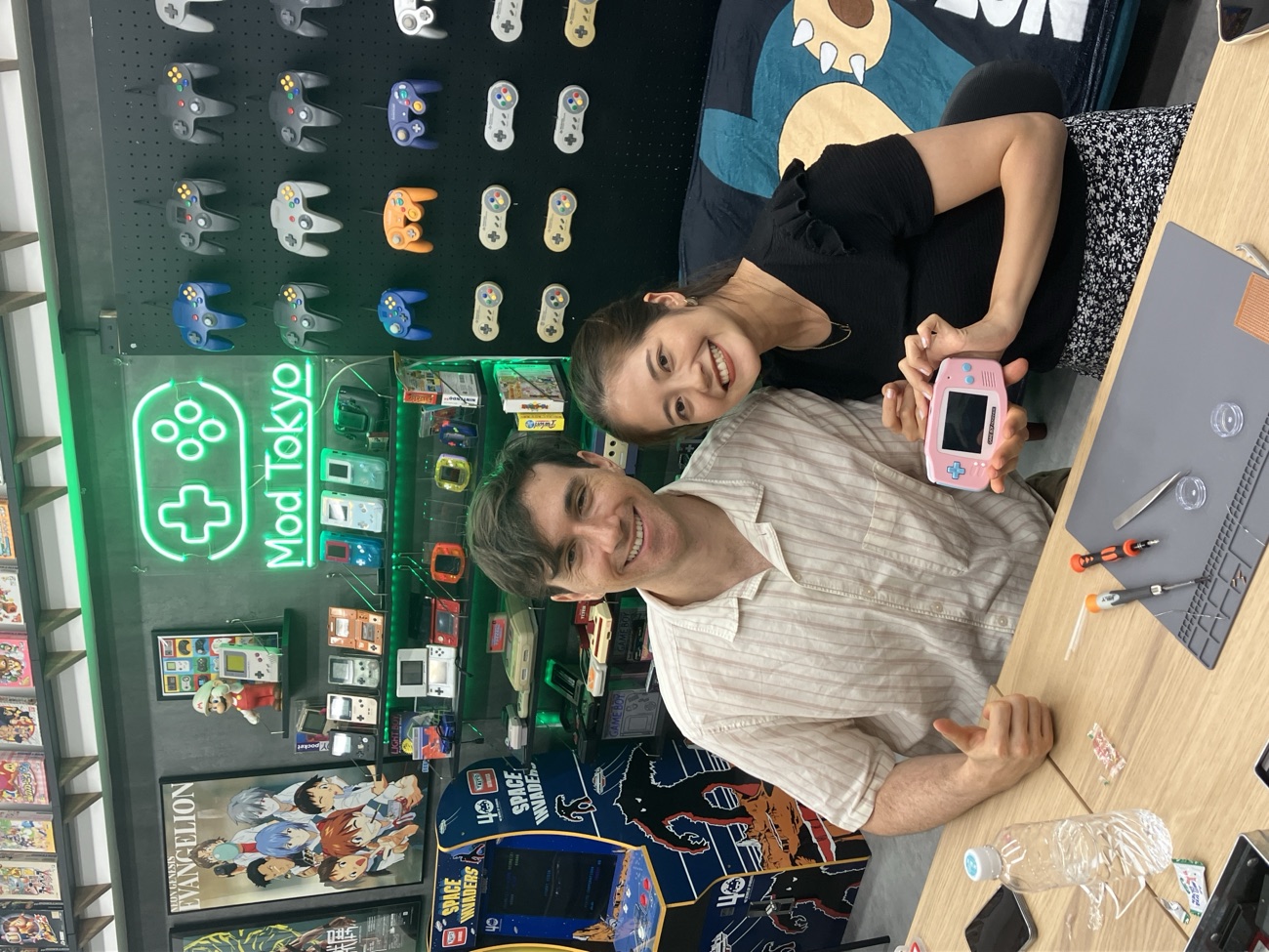 A couple giving a thumbs-up with their finished pink Game Boy Advance